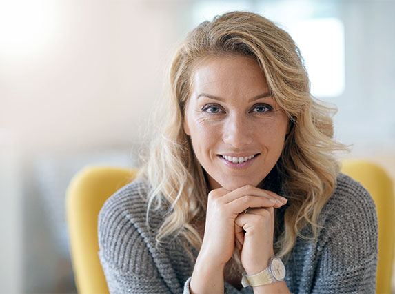 Woman resting chin on folded hands