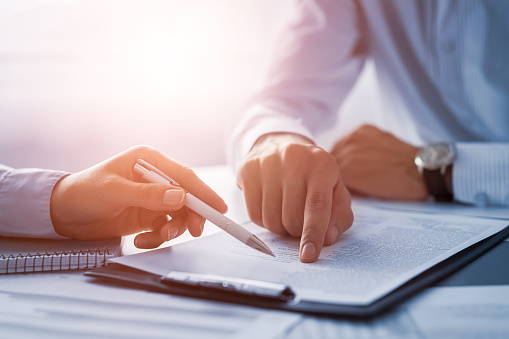 Dentist and patient point at paperwork and forms on a clipboard in our Houston dental office.