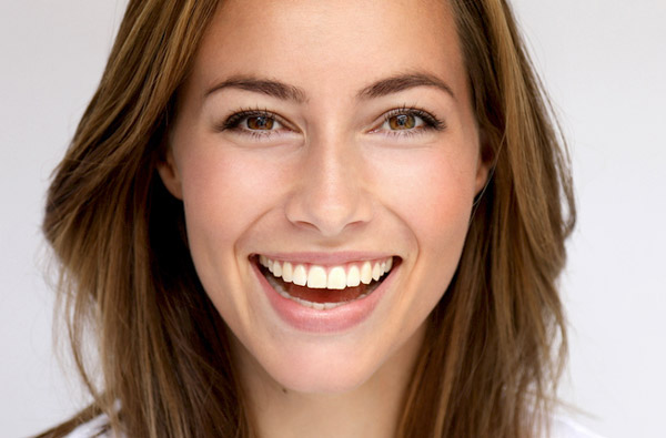 Beautiful woman smiling after getting cosmetic dentistry from Frank Dunlap, DDS in Houston.